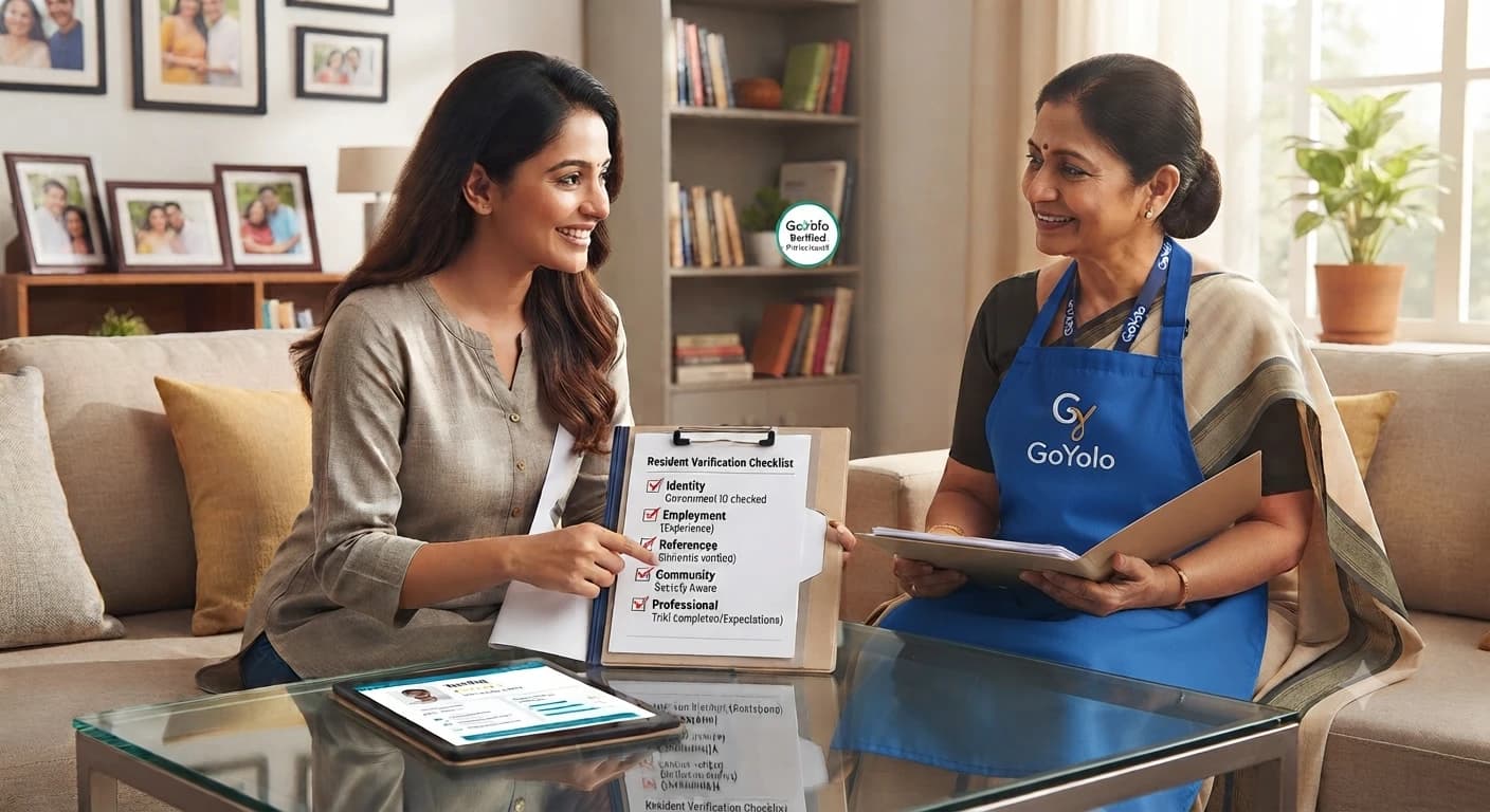 A resident going through a house help verification checklist with a domestic worker wearing a GoYolo apron in a living room